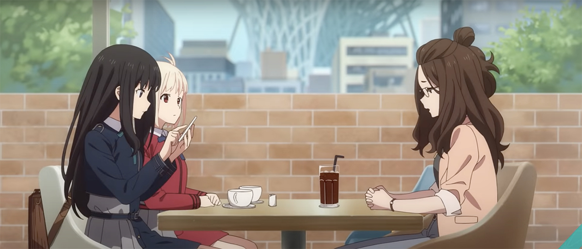 Three females sit at a cafe table